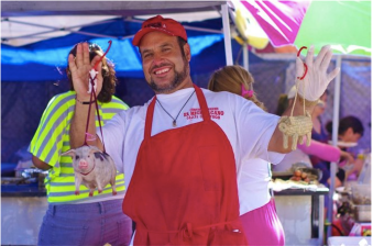 A street vendor in the piñata district holds up two cochinitos. Sahra Sulaiman/Streetsblog L.A
