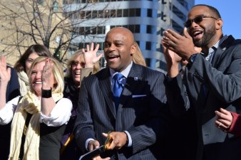 Denver Mayor Michael Hancock, center, joins other officials to cut the ribbon of a new protected bike lane, 2015. Photo: David Sachs, Streetsblog Denver.