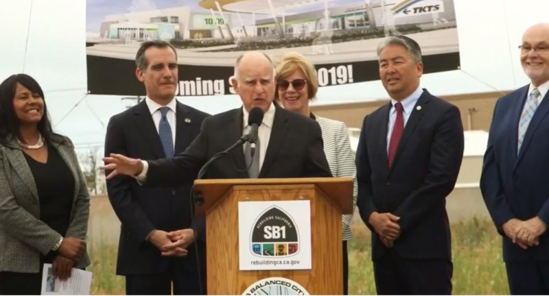 Governor Brown touting the benefits of CA's gas tax increase. Left to right are: Torrance Transit head Kim Turner, L.A. Mayor Eric Garcetti, CA Governor Jerry Brown, Supervisor Janice Hahn, Assemblymember Al Muratsuchi, and Torrance Mayor Patrick Furey. Screen capture via Muratsuchi Facebook video