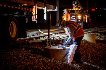A construction worker finishing up a electric pole foundation on Caltrain's mainline on the Peninsula. Image: Caltrain