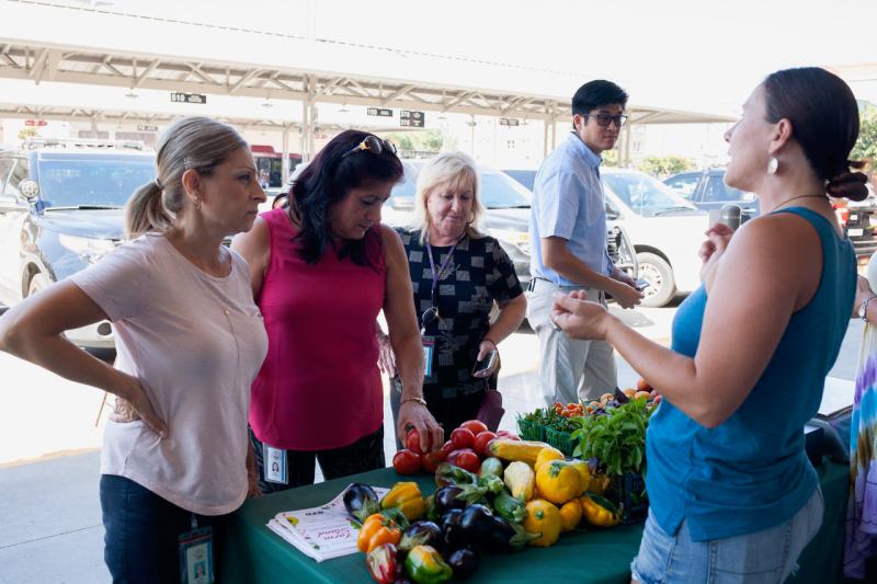 Jessica Bryant, healthy retail coordinator for PUENTES, talks to (left to right) Cynthia Sanchez, Lydia Dingman, and Maryann Hughes at the new farm stand in downtown Stockton. All photos by Minerva Perez
