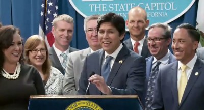 Senator Kevin de León, flanked by legislative and environmental leaders, celebrates the signing of his clean energy bill. Image: Screengrab from CA Senate.