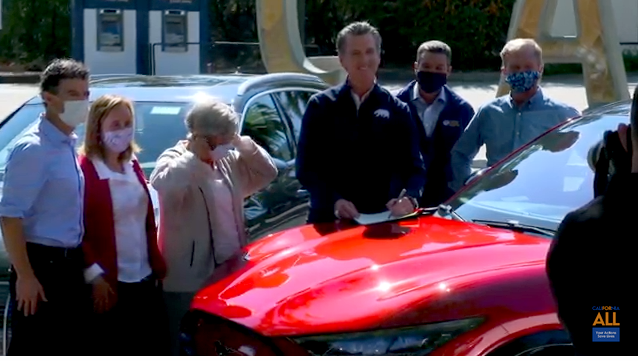 Governor Newsom signing executive order to phase out fossil fuel vehicles in California, on an electric car. Image: Screengrab from YouTube