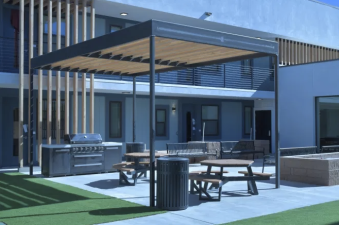 covered outdoor space with tables, stove